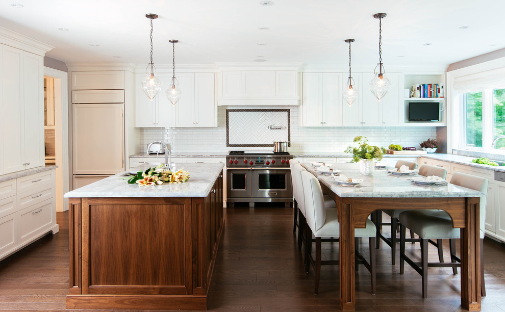 Inspiration for a large transitional u-shaped open plan kitchen in Toronto with an undermount sink, beaded inset cabinets, white cabinets, white splashback, stainless steel appliances, medium hardwood floors, multiple islands, quartzite benchtops, ceramic splashback and brown floor.