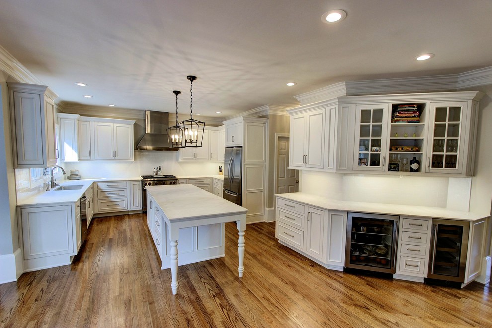 Kitchen pantry - large transitional u-shaped light wood floor kitchen pantry idea in Atlanta with an undermount sink, recessed-panel cabinets, white cabinets, quartz countertops, white backsplash, subway tile backsplash, stainless steel appliances and an island
