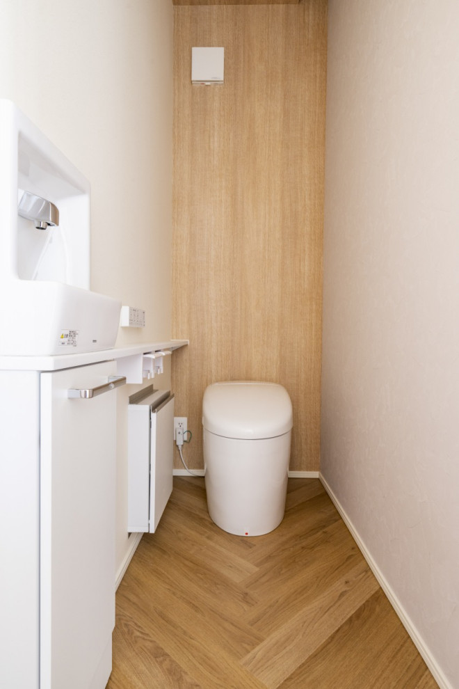 Inspiration for a medium sized modern cloakroom in Other with a bidet, multi-coloured walls, light hardwood flooring, brown floors, a feature wall, a wallpapered ceiling and wallpapered walls.