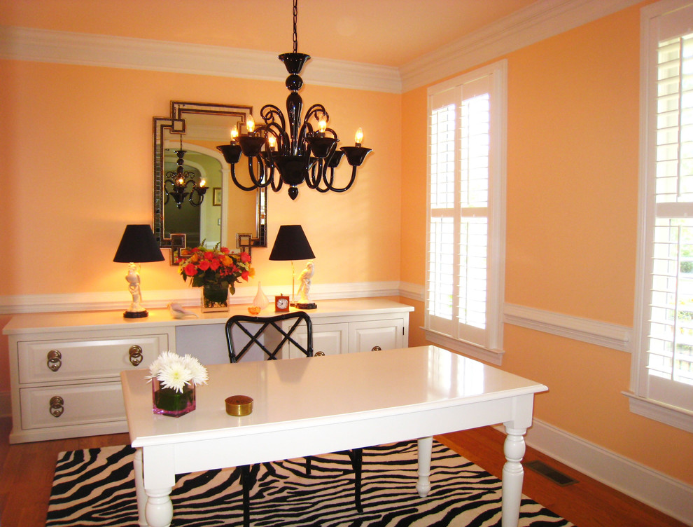 Transitional home office in Miami with orange walls, dark hardwood floors and a freestanding desk.