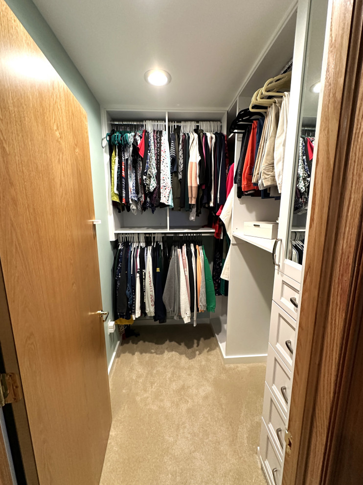 This is an example of a mid-sized midcentury gender-neutral storage and wardrobe in Detroit with shaker cabinets, white cabinets, carpet and beige floor.