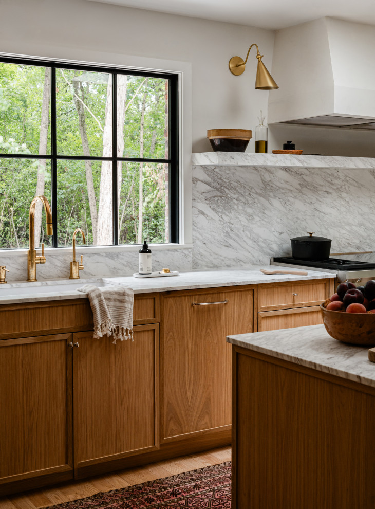 Mid-sized transitional l-shaped light wood floor eat-in kitchen photo in Chicago with an undermount sink, shaker cabinets, light wood cabinets, marble countertops, white backsplash, marble backsplash, paneled appliances, an island and white countertops