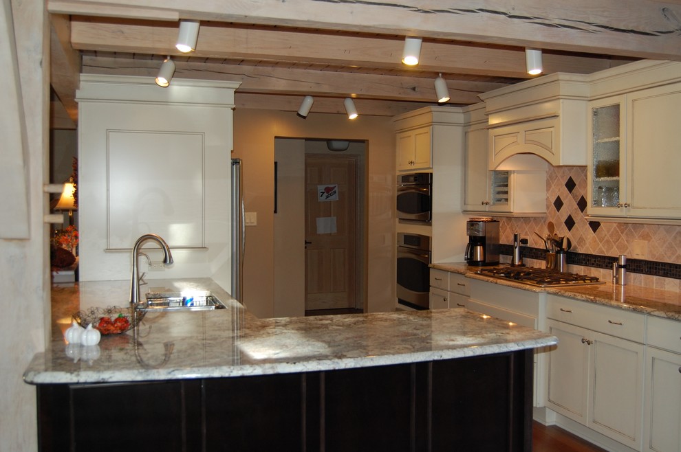 Example of a mid-sized transitional u-shaped medium tone wood floor open concept kitchen design in Chicago with an undermount sink, flat-panel cabinets, dark wood cabinets, granite countertops, beige backsplash, stone tile backsplash, stainless steel appliances and a peninsula
