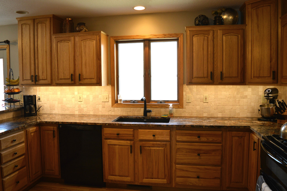 Inspiration for a mid-sized transitional u-shaped light wood floor open concept kitchen remodel in Cedar Rapids with an undermount sink, light wood cabinets, granite countertops, beige backsplash, stone tile backsplash, black appliances, no island and shaker cabinets
