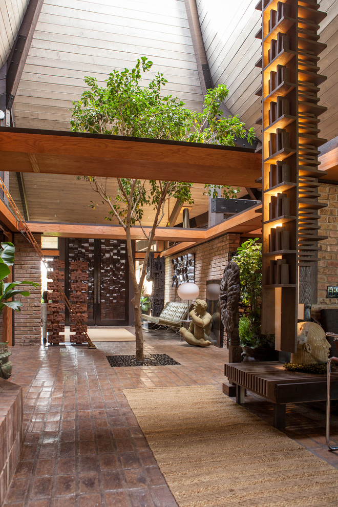 Inspiration for a large eclectic brick floor foyer remodel in Chicago with beige walls and a dark wood front door