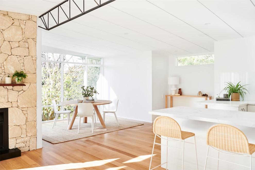 Mid-sized beach style light wood floor and brown floor great room photo in Melbourne with white walls