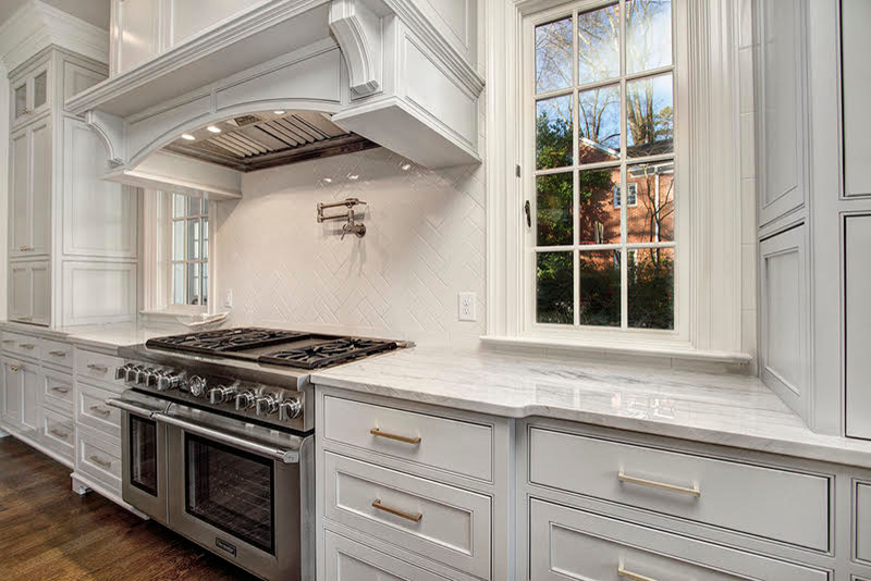 Inspiration for a galley dark wood floor eat-in kitchen remodel in Charlotte with marble countertops, white backsplash, glass tile backsplash and stainless steel appliances