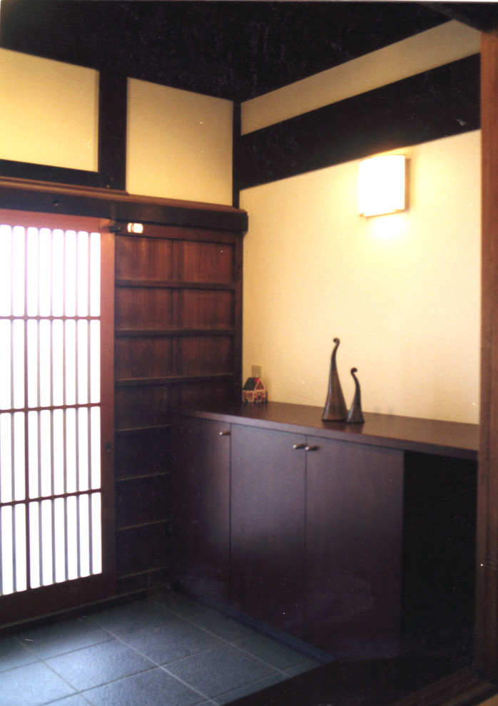 This is an example of an asian entryway in Tokyo Suburbs with a sliding front door, a medium wood front door and grey floor.