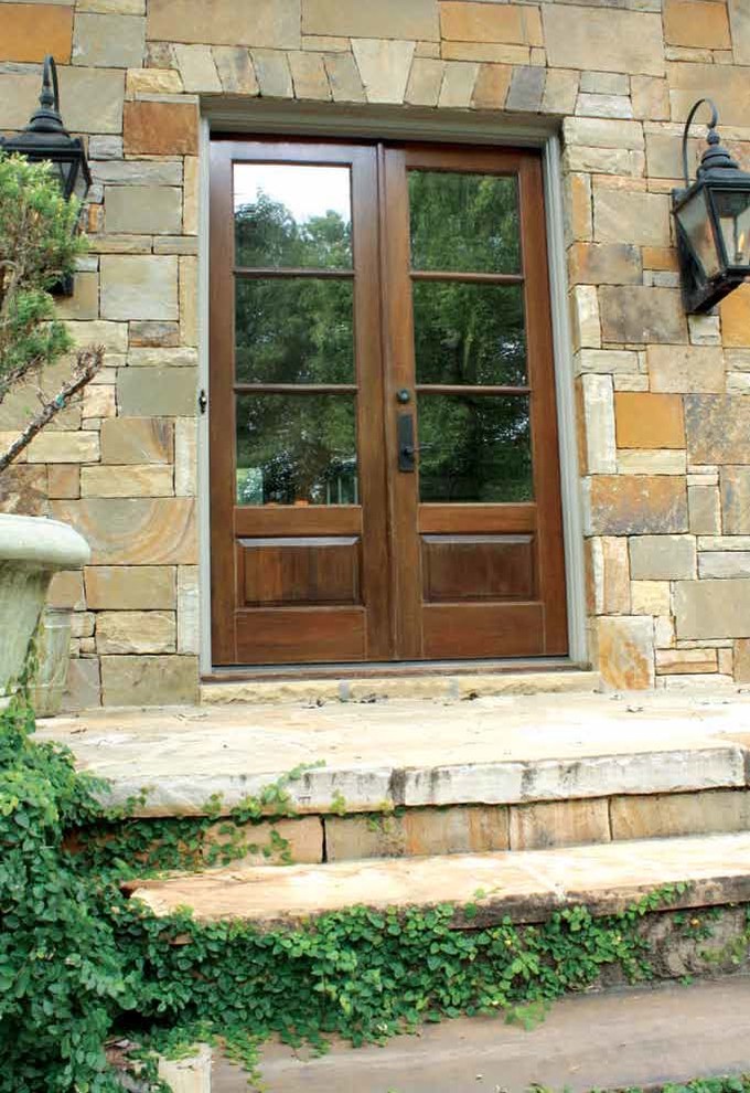 Photo of a mid-sized transitional front door in Tampa with brown walls, a double front door and a light wood front door.