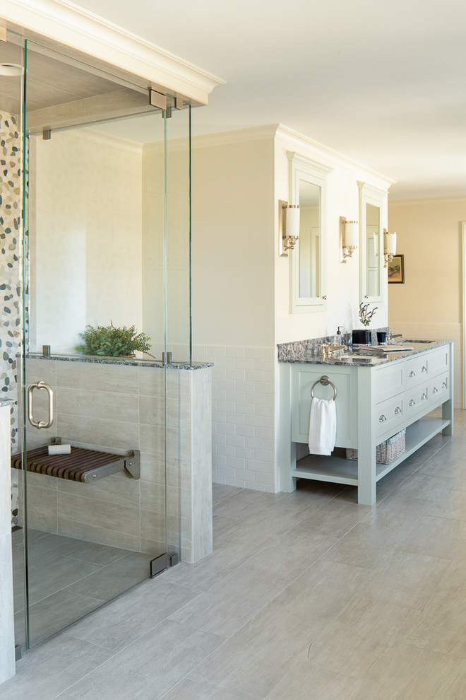 Photo of a transitional master bathroom in Portland Maine with a curbless shower, multi-coloured tile, beige walls, an undermount sink, shaker cabinets, porcelain floors and a hinged shower door.