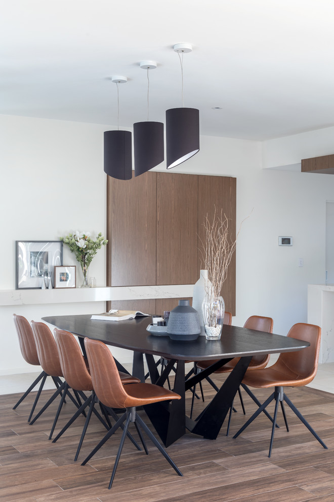 Contemporary open plan dining in Perth with white walls and brown floor.