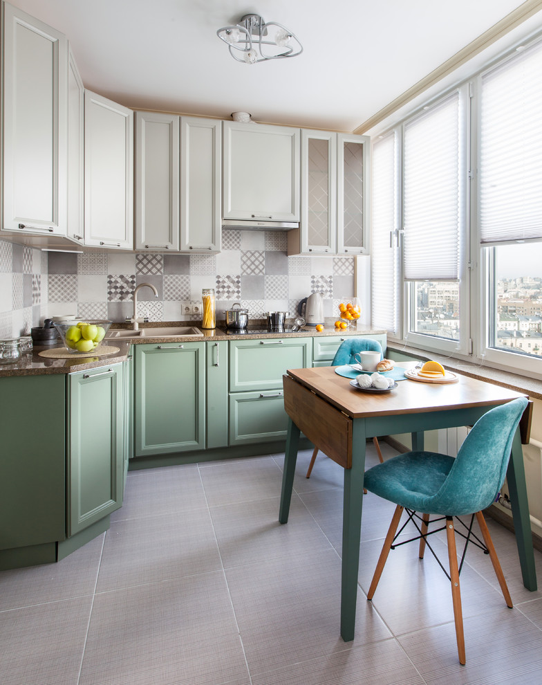 Photo of a small transitional l-shaped eat-in kitchen in Moscow with a drop-in sink, recessed-panel cabinets, green cabinets, grey splashback, no island and grey floor.