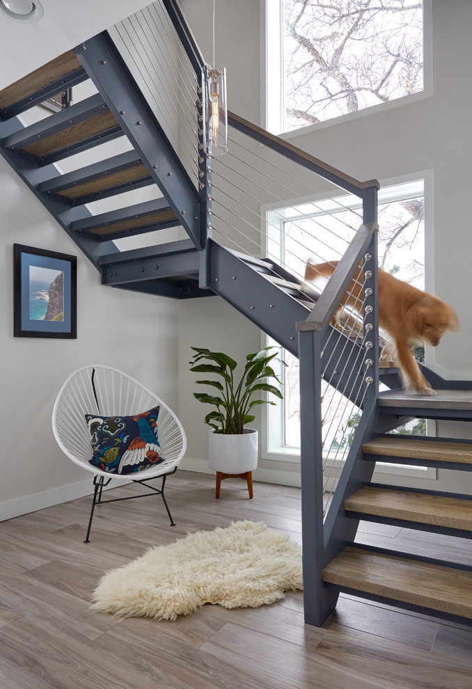 Photo of a beach style wood u-shaped staircase in Portland Maine with open risers and cable railing.
