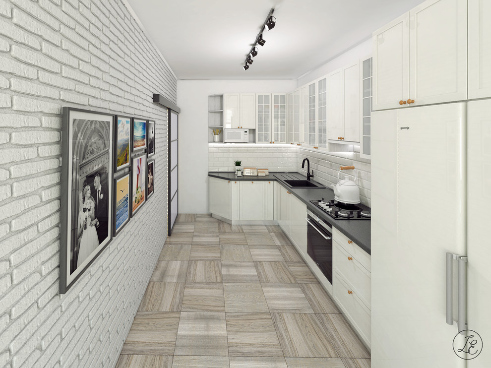 This is an example of a mid-sized scandinavian l-shaped eat-in kitchen in Other with a drop-in sink, recessed-panel cabinets, white cabinets, granite benchtops, white splashback, subway tile splashback, black appliances, ceramic floors, no island and grey floor.