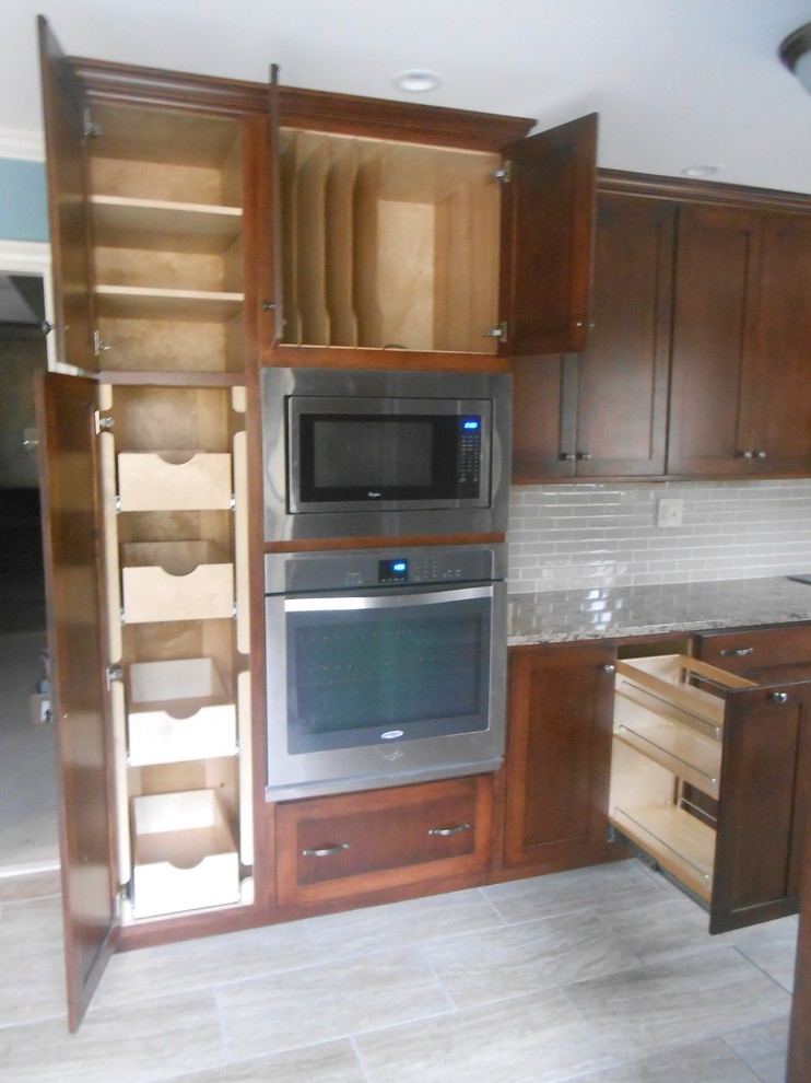 Inspiration for a mid-sized transitional galley porcelain tile eat-in kitchen remodel with an undermount sink, shaker cabinets, dark wood cabinets, quartz countertops, beige backsplash, glass sheet backsplash, stainless steel appliances, blue walls and no island