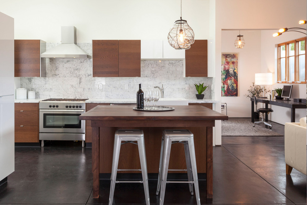 This is an example of a contemporary kitchen in San Francisco with flat-panel cabinets, dark wood cabinets, white splashback, stone tile splashback and stainless steel appliances.