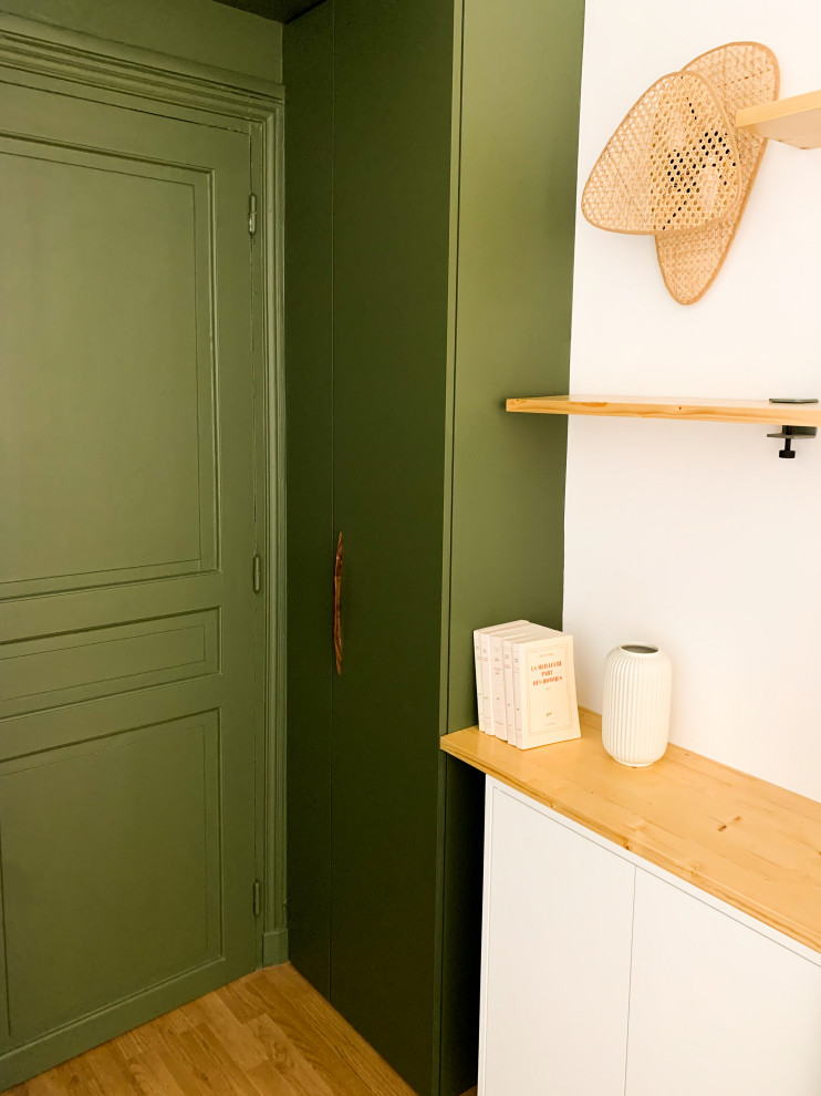 Modelo de entrada contemporánea pequeña con paredes verdes, suelo laminado, puerta simple, puerta verde y bandeja