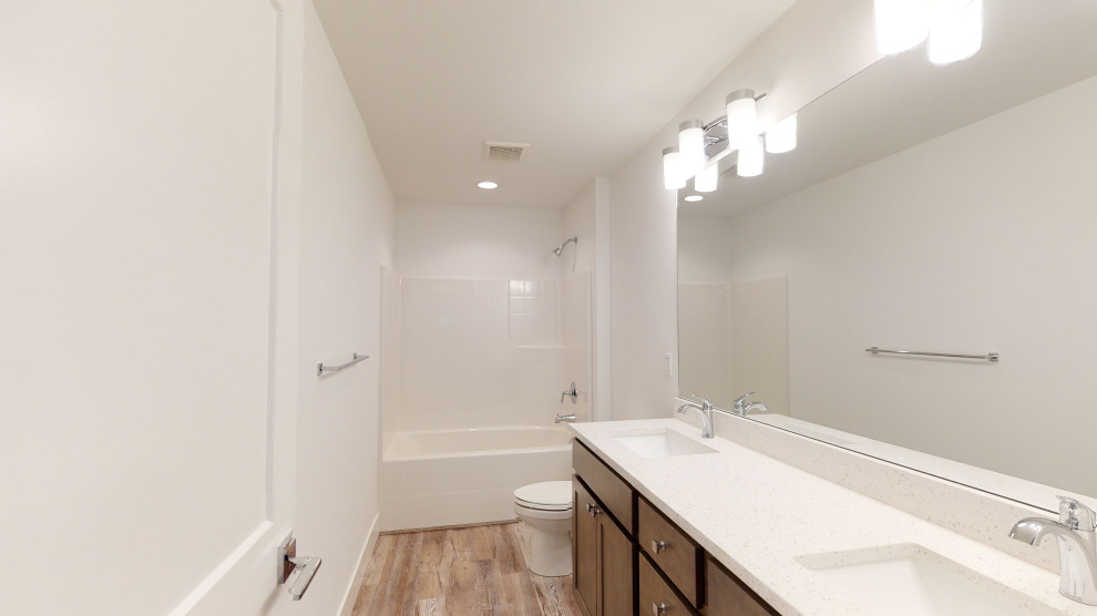 Immagine di una stanza da bagno tradizionale con ante in stile shaker, ante marroni, piastrelle bianche, top in quarzite, top bianco, due lavabi e mobile bagno incassato