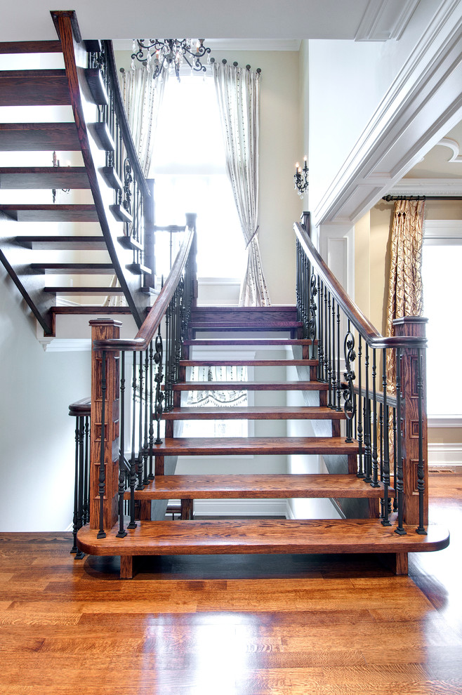 Design ideas for a mid-sized traditional wood curved staircase in Toronto with open risers.
