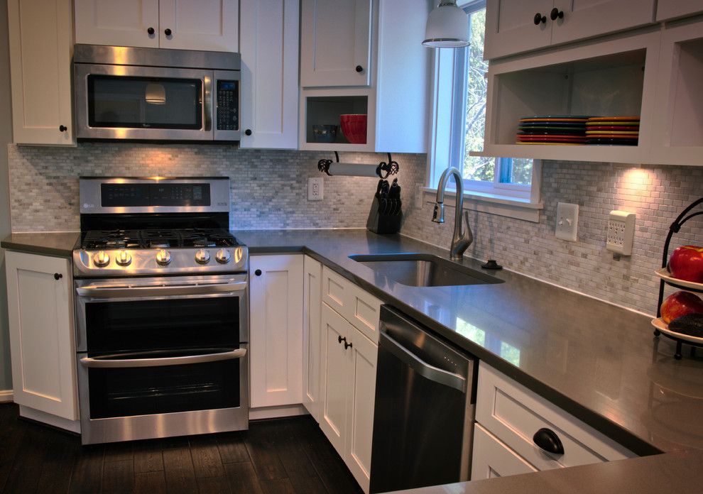 Mid-sized transitional u-shaped dark wood floor and brown floor kitchen photo in DC Metro with an undermount sink, shaker cabinets, white cabinets, quartz countertops, gray backsplash, matchstick tile backsplash, stainless steel appliances and a peninsula
