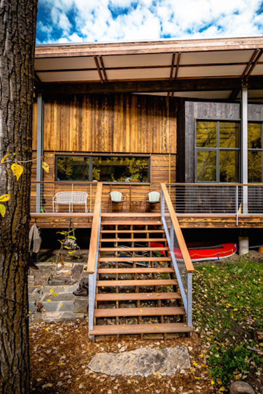 Example of a trendy side yard balcony deck design with a roof extension