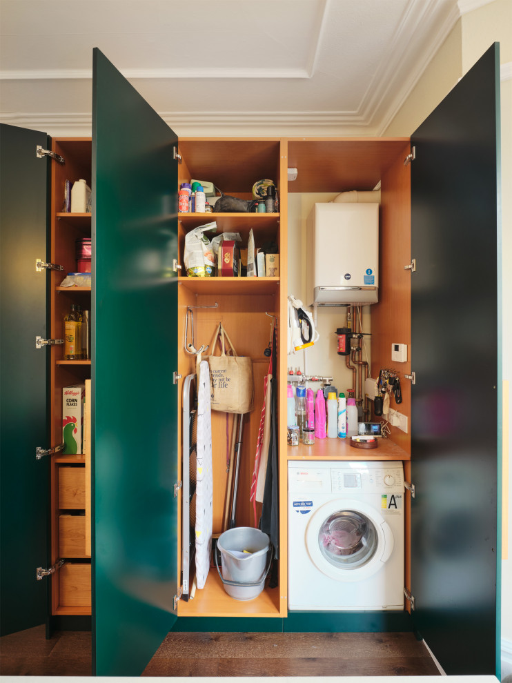 Mittelgroße Moderne Küche in L-Form mit flächenbündigen Schrankfronten, grünen Schränken, Küchenrückwand in Metallic, Kücheninsel und weißer Arbeitsplatte in London
