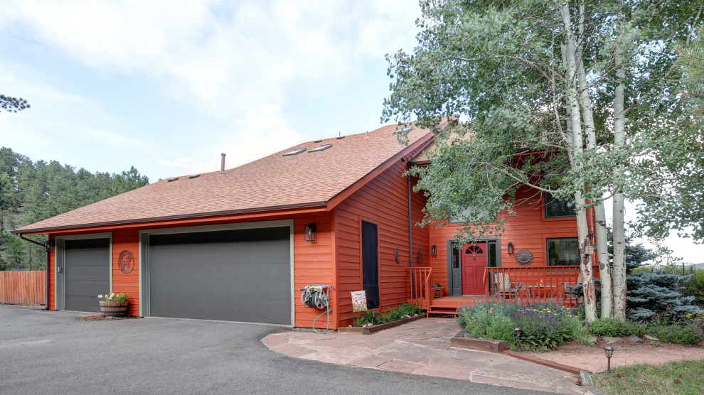 This is an example of a large country three-storey red house exterior in Denver with concrete fiberboard siding, a gable roof and a shingle roof.