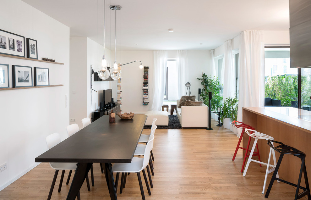Inspiration for a contemporary kitchen/dining combo in Berlin with white walls and medium hardwood floors.