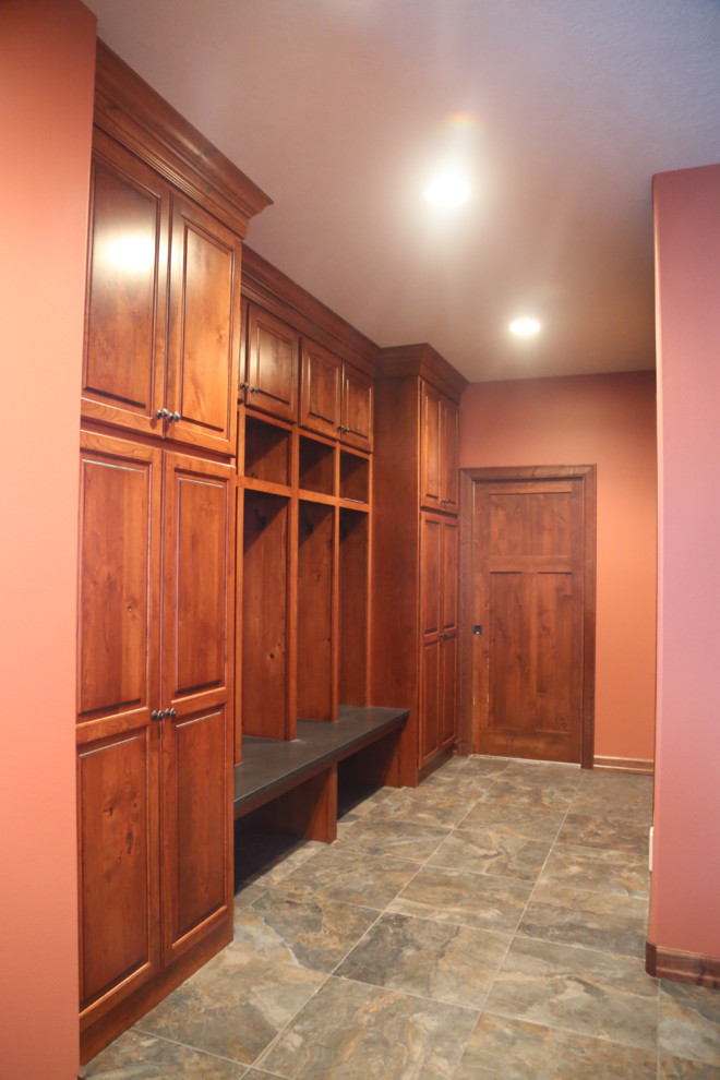 Photo of a mid-sized traditional mudroom in Other with red walls, porcelain floors, a single front door and a dark wood front door.