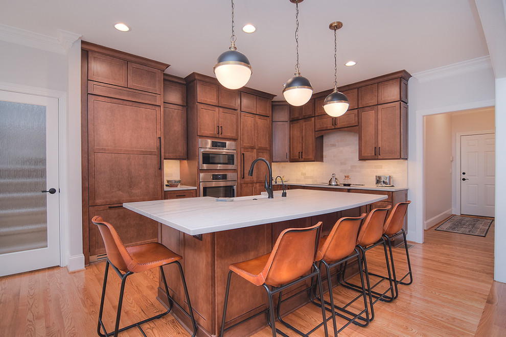 Inspiration for a huge transitional light wood floor open concept kitchen remodel in Charlotte with a farmhouse sink, shaker cabinets, medium tone wood cabinets, quartzite countertops, an island and white countertops