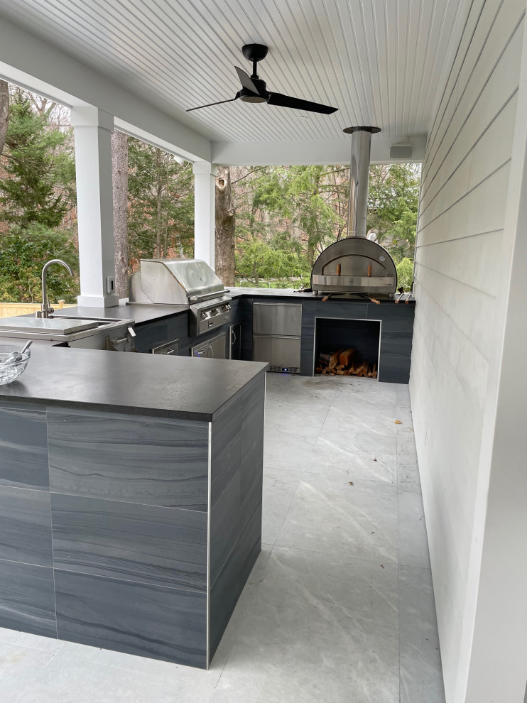 Large minimalist backyard concrete patio kitchen photo in New York with a roof extension