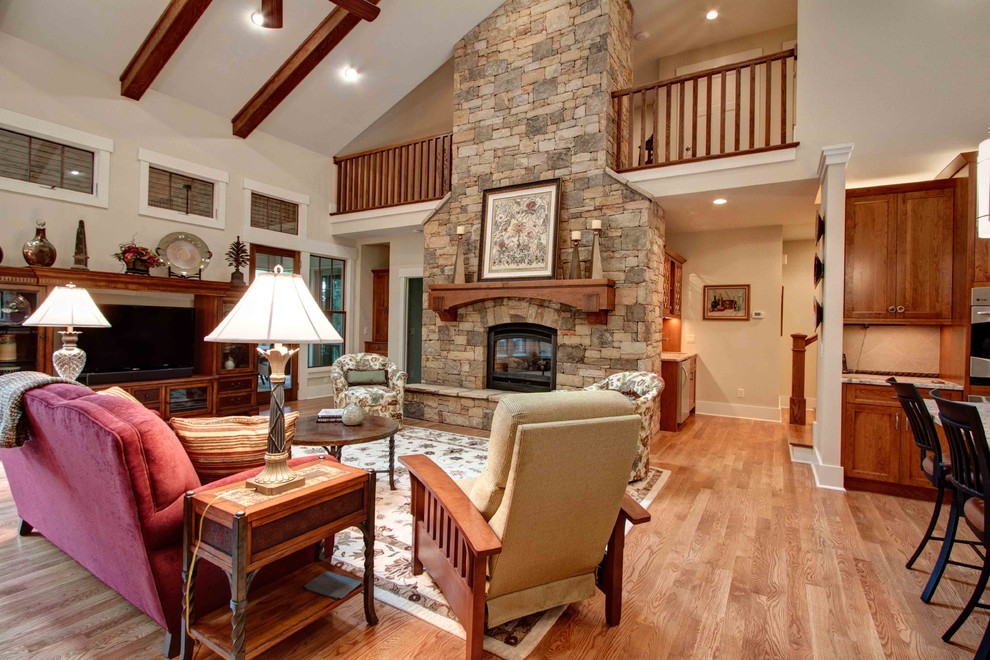 Inspiration for a traditional open concept living room in Other with white walls, light hardwood floors, a standard fireplace, a stone fireplace surround and a freestanding tv.