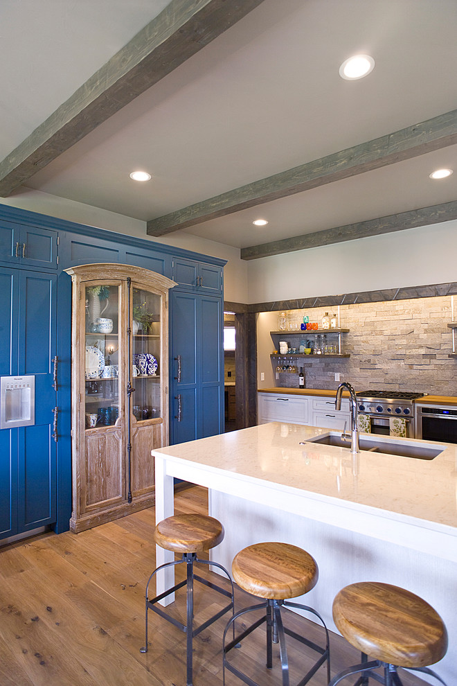 Inspiration for a large transitional l-shaped light wood floor and brown floor eat-in kitchen remodel with an undermount sink, recessed-panel cabinets, white cabinets, quartz countertops, multicolored backsplash, stone tile backsplash, stainless steel appliances and an island