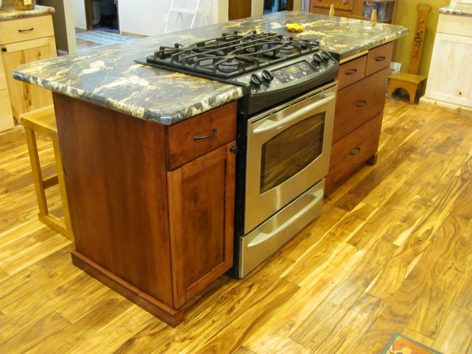Mid-sized mountain style l-shaped light wood floor and beige floor eat-in kitchen photo with a double-bowl sink, shaker cabinets, light wood cabinets, limestone countertops, stainless steel appliances and an island