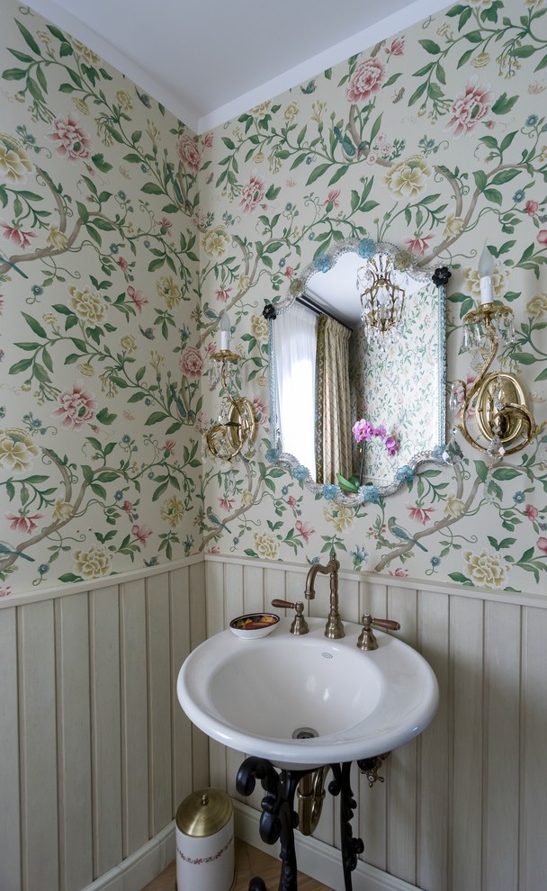 This is an example of a transitional powder room in Moscow with green walls and a console sink.
