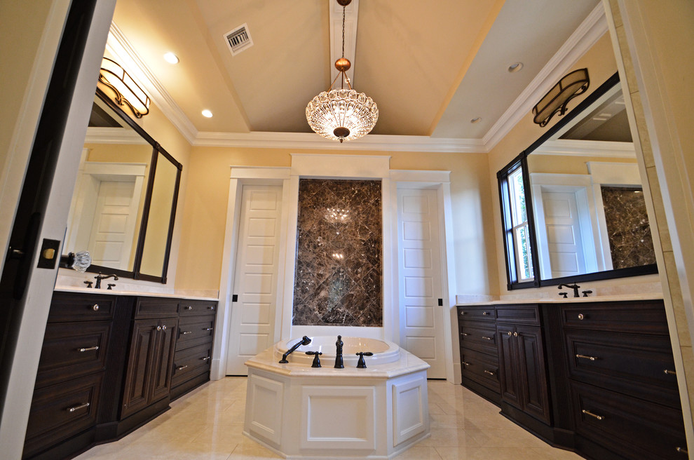 Photo of a large traditional master bathroom in New Orleans with raised-panel cabinets, dark wood cabinets, a freestanding tub, white tile and yellow walls.