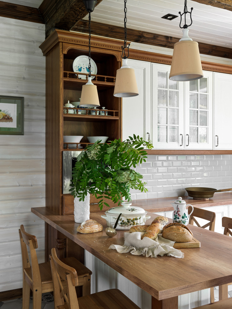 На фото: кухня-столовая среднего размера в классическом стиле с белыми стенами, полом из керамической плитки, угловым камином, фасадом камина из камня, серым полом, балками на потолке и стенами из вагонки с