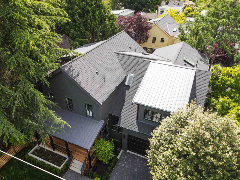Идея дизайна: двухэтажный, разноцветный частный загородный дом среднего размера в стиле модернизм с комбинированной облицовкой, двускатной крышей, крышей из смешанных материалов, черной крышей и отделкой планкеном