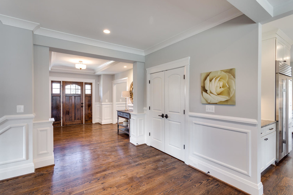 This is an example of a transitional entry hall in DC Metro with grey walls, medium hardwood floors, a single front door and a medium wood front door.