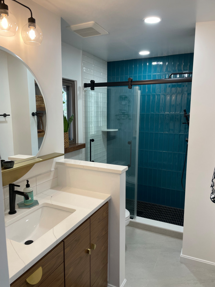 Medium sized modern ensuite bathroom in DC Metro with flat-panel cabinets, brown cabinets, an alcove shower, a one-piece toilet, white tiles, porcelain tiles, white walls, porcelain flooring, a submerged sink, quartz worktops, grey floors, a sliding door, white worktops, a wall niche, a single sink and a built in vanity unit.