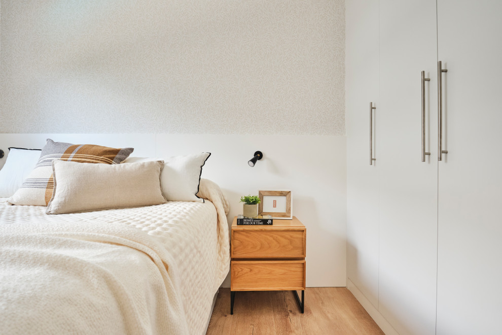 Imagen de habitación de invitados blanca y madera tradicional renovada grande sin chimenea con paredes beige, suelo de madera en tonos medios, suelo marrón y papel pintado