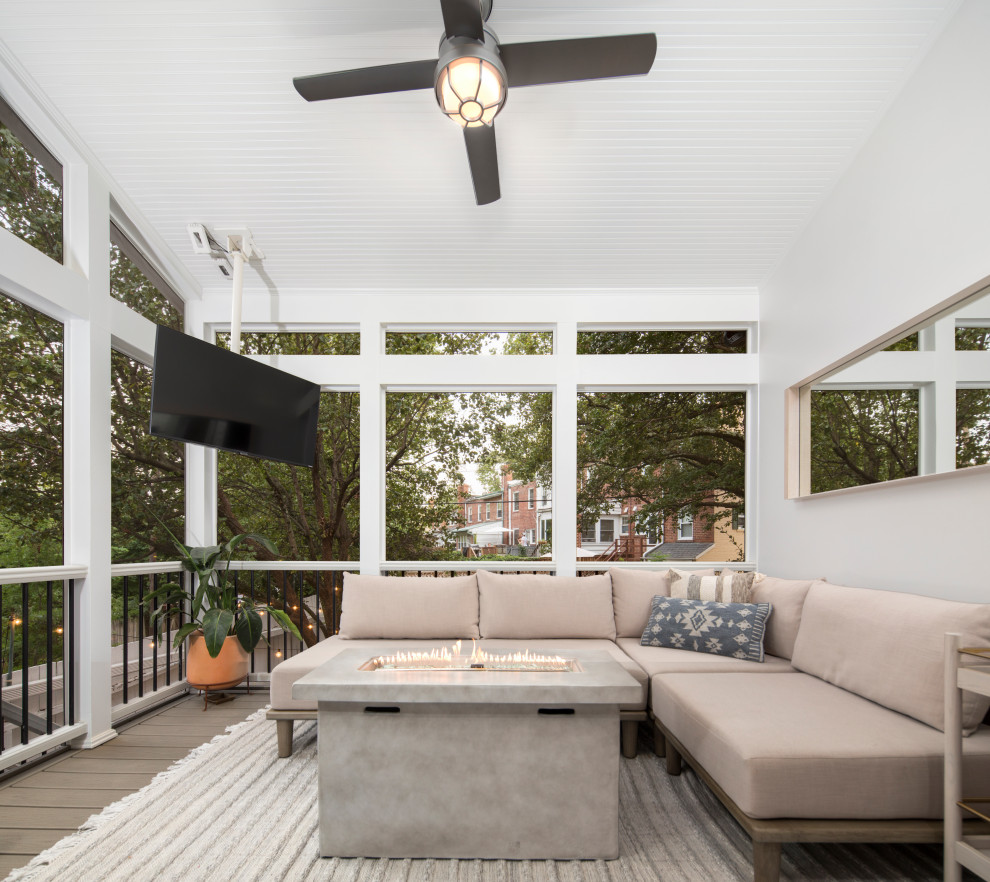 Contemporary backyard verandah in DC Metro with a fire feature, decking, a roof extension and wood railing.