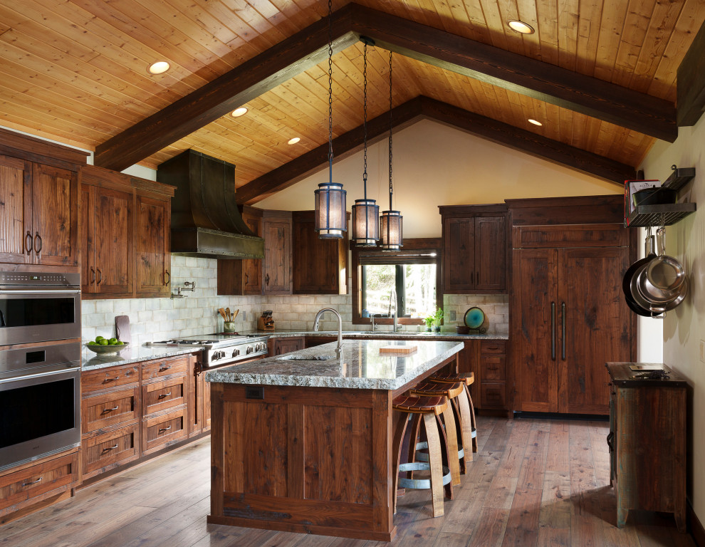 Kitchen - rustic l-shaped dark wood floor, brown floor, exposed beam, vaulted ceiling and wood ceiling kitchen idea with an undermount sink, shaker cabinets, dark wood cabinets, gray backsplash, paneled appliances, an island and gray countertops