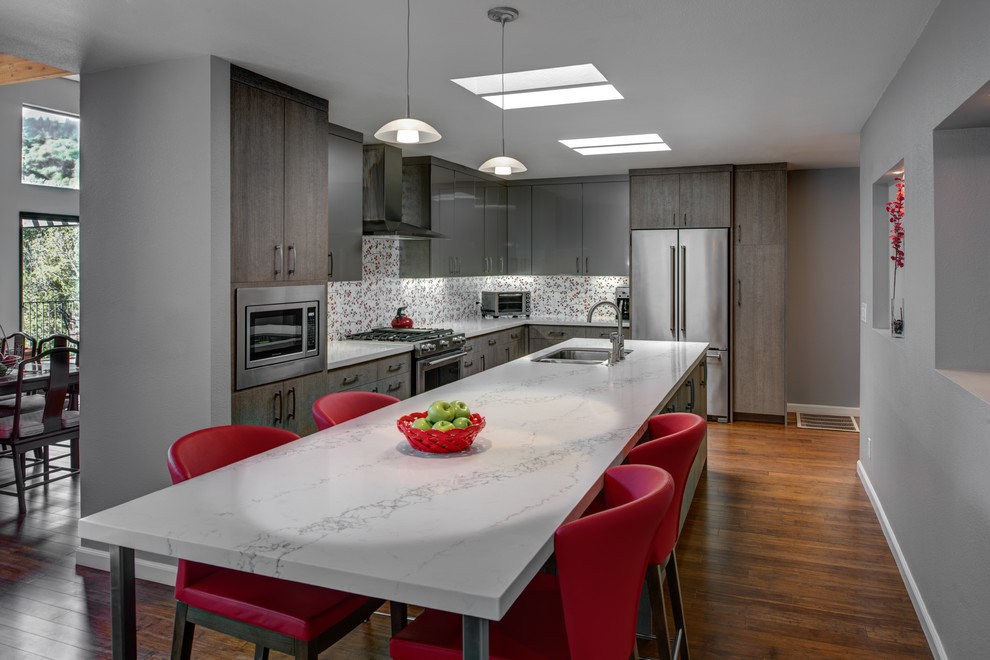 Inspiration for a mid-sized contemporary l-shaped eat-in kitchen in San Francisco with an undermount sink, flat-panel cabinets, grey cabinets, quartz benchtops, red splashback, porcelain splashback, stainless steel appliances, medium hardwood floors and with island.