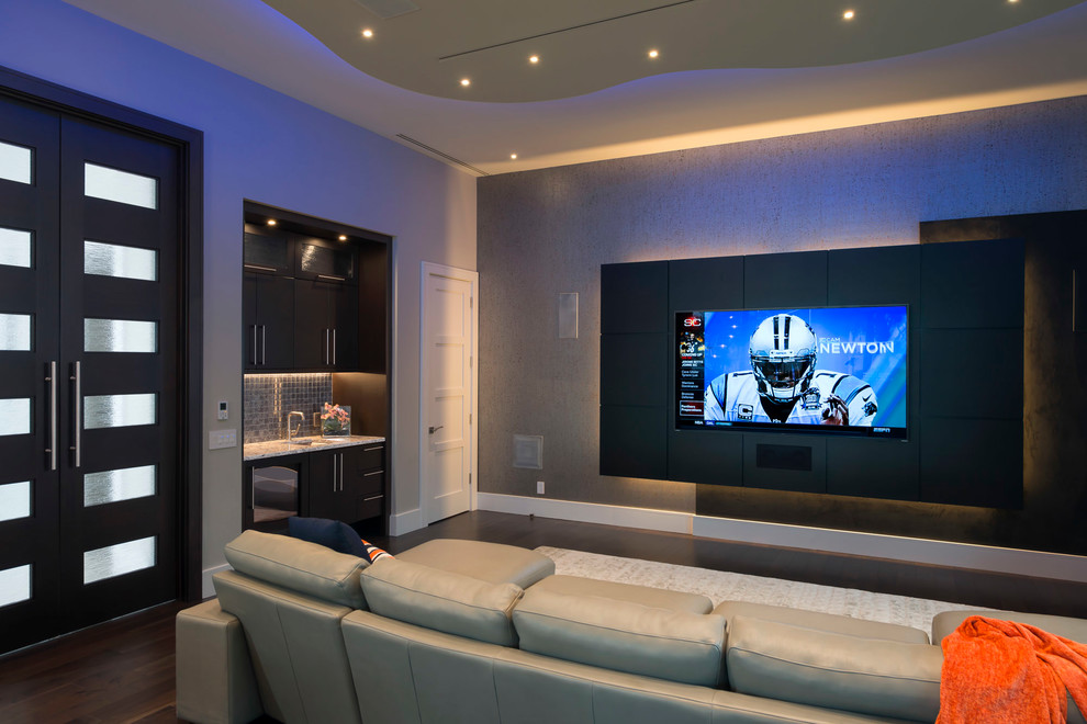 Inspiration for a contemporary open concept home theater remodel in Orlando with beige walls and a wall-mounted tv