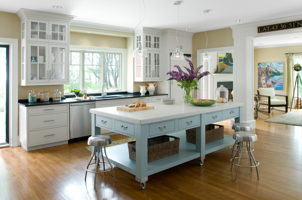 Inspiration for a traditional galley kitchen in Portland Maine with glass-front cabinets, white cabinets and panelled appliances.