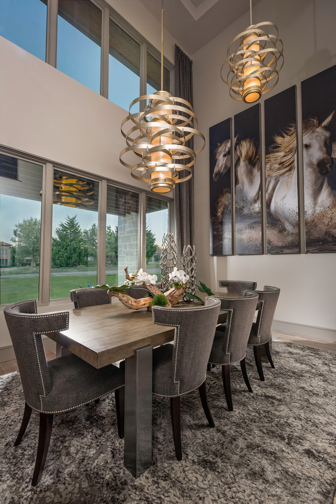Foto di una sala da pranzo aperta verso la cucina moderna con pareti beige, parquet chiaro e pavimento beige