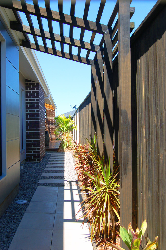 Photo of a small contemporary side yard partial sun outdoor sport court for summer in Other with concrete pavers and a garden path.