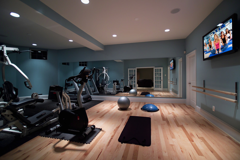 Inspiration for a modern home gym in DC Metro with blue walls and light hardwood floors.
