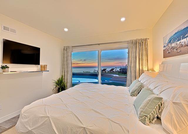 Photo of a mid-sized beach style guest bedroom in San Diego with white walls, ceramic floors and no fireplace.